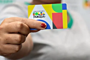 Mãos inspecionando urna eletrônica no Congresso Nacional, simbolizando votação de projeto.