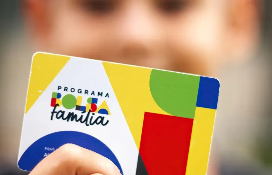 Família brasileira recebendo benefício do Bolsa Família com expressão de alívio.
