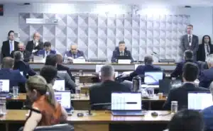 Sala de audiência da CPMI do INSS no Senado Federal, com mesa vazia e bandeira do Brasil ao fundo.