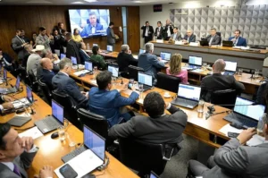 Sala de reunião do Congresso Nacional com mesa de conferência e microfones.