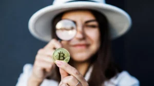 Martelo de juiz em cima de livros de direito com gráficos de criptomoedas ao fundo em um tribunal