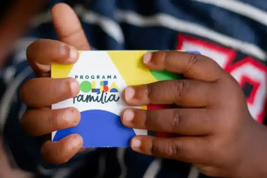 Mãe com filhos recebendo informações sobre o Bolsa Família em um centro comunitário.