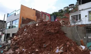Rua inundada com escombros e destruição em cidade mineira após tempestades.