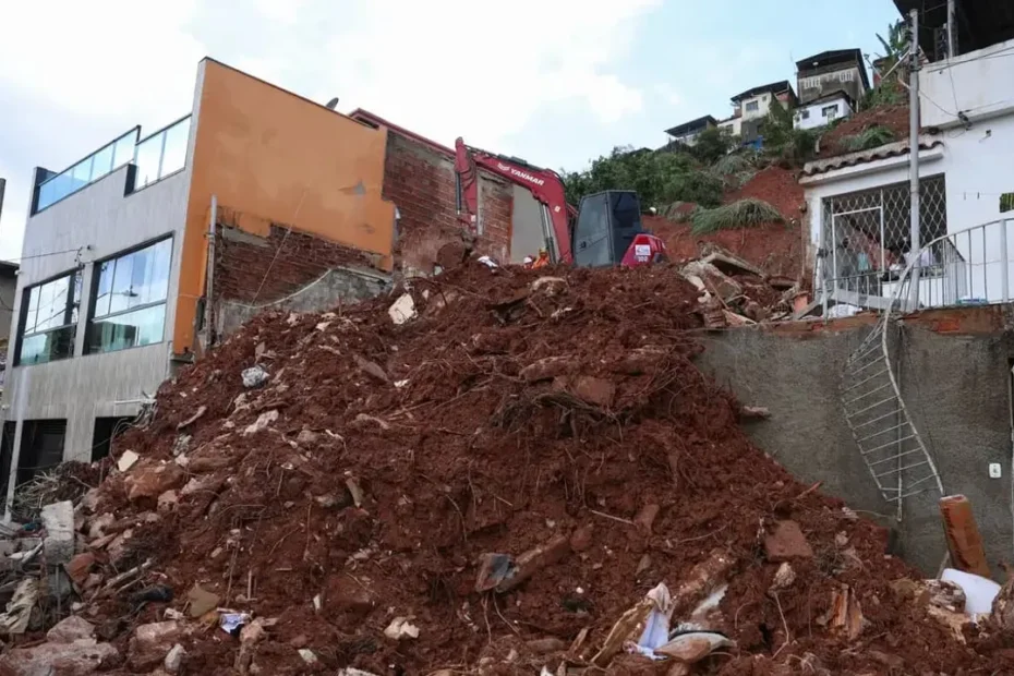 Rua inundada com escombros e destruição em cidade mineira após tempestades.