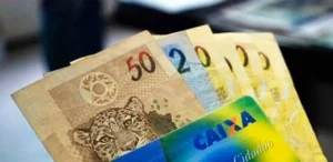 Trabalhador confere pagamento do abono salarial PIS/Pasep 2026 pelo celular.
