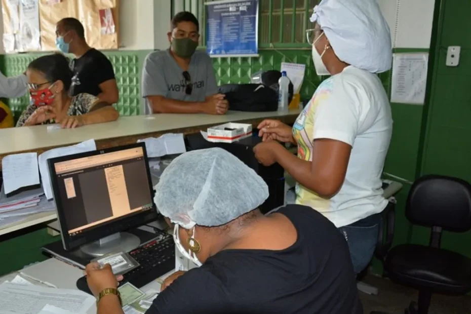 Enfermeira mede a altura de uma criança em unidade de saúde enquanto mãe observa.