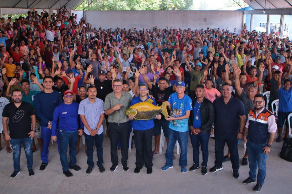 Pescadores do Amazonas em situação de preocupação, com seus barcos ao fundo