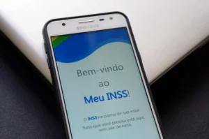 Aposentado feliz recebendo a notícia da antecipação do 13º salário do INSS pelo celular.