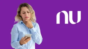 Mão inserindo cartão Nubank em caixa eletrônico, simbolizando a taxa de saque.