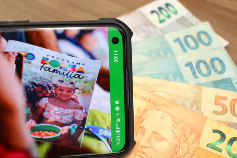 Mulher brasileira consulta aplicativo do Bolsa Família no celular ao lado dos filhos