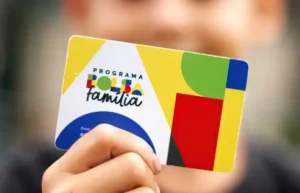 Mulher preocupada checando informações do Bolsa Família no celular