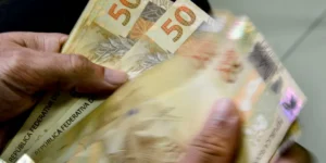Beneficiária do Bolsa Família consulta aplicativo Caixa Tem no celular