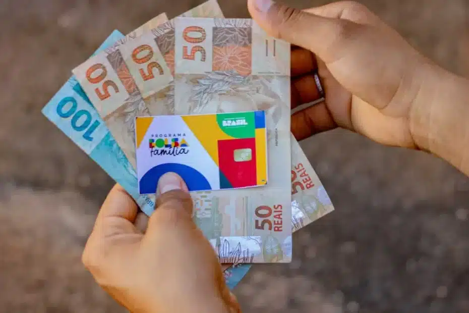 Família recebe cartão do Bolsa Família em agência lotérica.