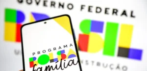 Mulher sorri ao conferir informações do Bolsa Família em março de 2026