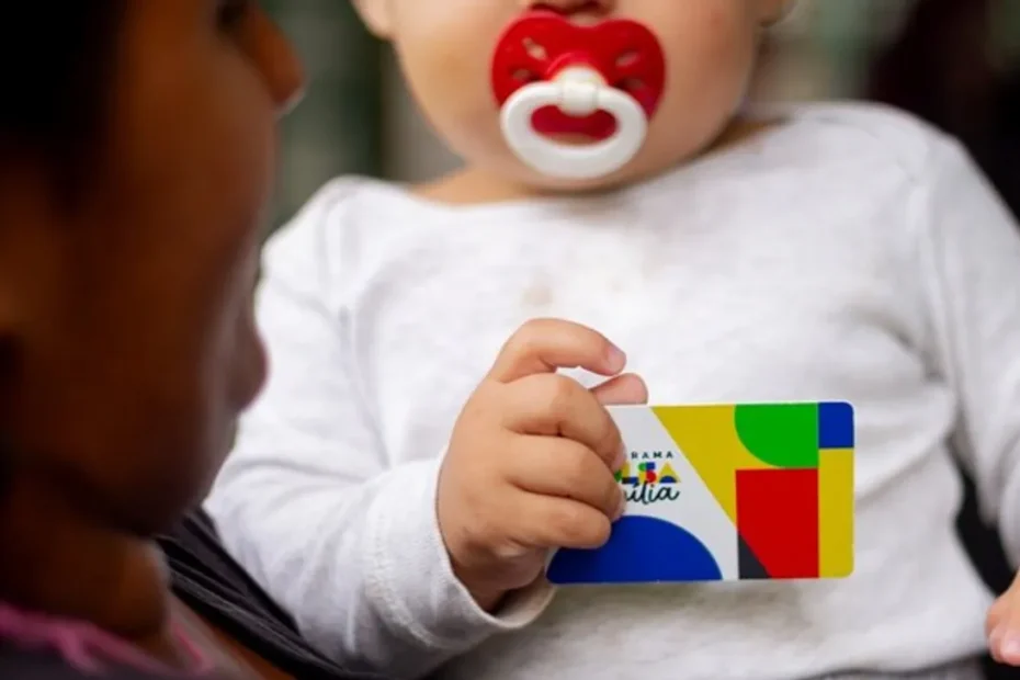Mulher recebendo cartão do Bolsa Família em agência da Caixa.
