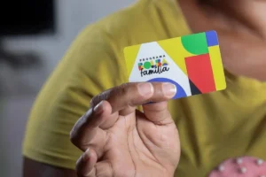 Mãe sorrindo preenchendo formulário no CRAS para atualizar dados do Bolsa Família.