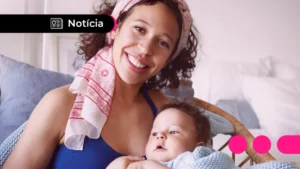 Mãos segurando um celular com o aplicativo Caixa Tem e cédulas de Real, simbolizando o pagamento do Bolsa Família.