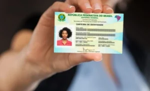 Funcionário público entrega nova Carteira de Identidade Nacional para beneficiária do Bolsa Família.