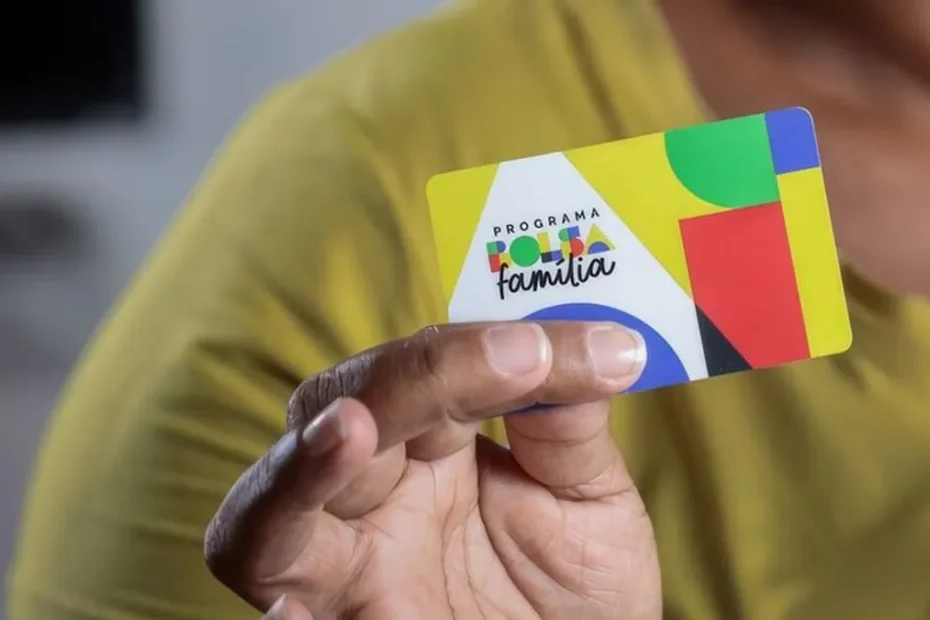 Mulher sorri ao verificar pagamento do Bolsa Família no celular.