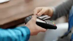 Mão segurando cartão de crédito em ambiente de compras
