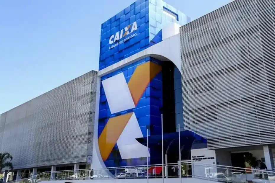 Fachada iluminada de uma agência da Caixa Econômica Federal com o logo em destaque.