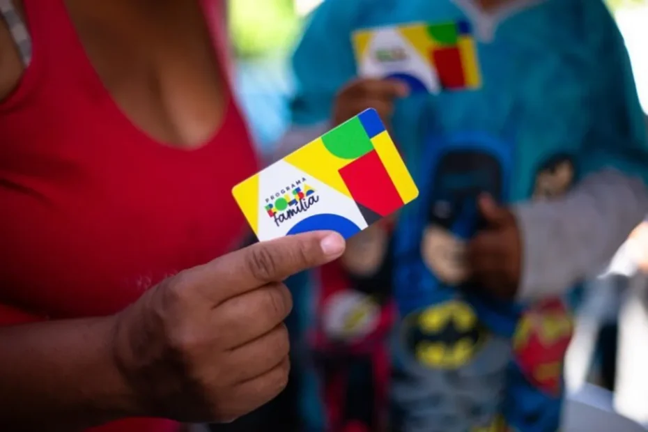 Família brasileira recebendo cartão do Bolsa Família de assistente social.