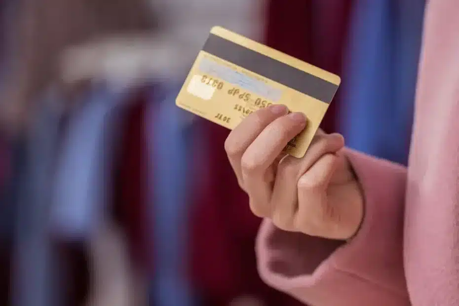 Mão segurando um cartão de crédito premium em um ambiente de luxo, representando benefícios de viagem.