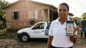 Morador utilizando aplicativo bancário após enchente, simbolizando acesso ao saque calamidade do FGTS