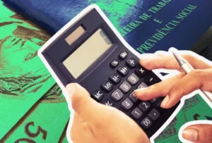 Mão segurando smartphone com aplicativo Carteira de Trabalho Digital exibindo informações de abono salarial.