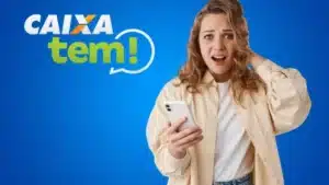 Pessoa olhando o celular com o saldo zerado no aplicativo Caixa Tem, expressando preocupação.