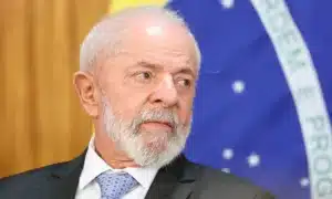 Mulher sorri ao receber botijão de gás de cozinha gratuito