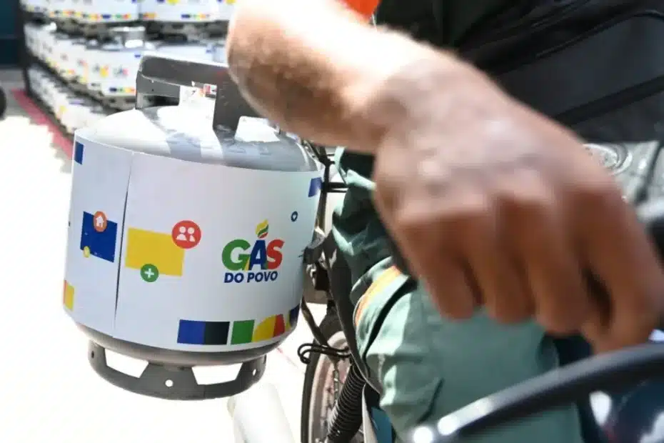 Mulher olha para botijão de gás de cozinha vazio, representando a dificuldade de acesso.