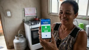 Mulher de baixa renda recebe botijão de gás gratuito do programa Gás do Povo.