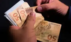 Aposentado feliz ao receber informações sobre o 13º salário do INSS antecipado.