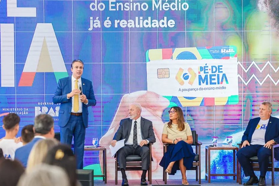 Cartão de benefício do Pé-de-Meia sobre documentos, com prédios governamentais ao fundo.