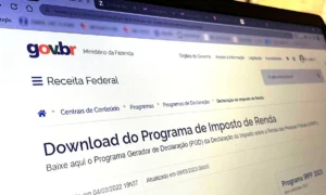 Pessoa entregando documentos em um balcão da Receita Federal para declaração de Imposto de Renda.