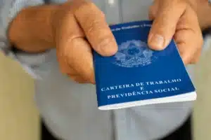 Homem preocupado com carteira de trabalho sem registro em frente ao INSS