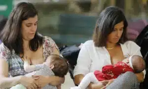 Mãe de primeira viagem com seu bebê recém-nascido recebendo apoio financeiro.