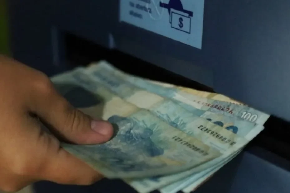 Mãos de trabalhador segurando celular com notícia sobre mudança na multa do FGTS