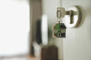 Família brasileira feliz segurando a chave de uma casa nova, simbolizando o acesso à moradia.