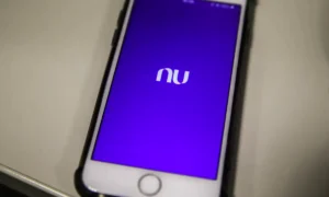 Pessoa preocupada com conta Nubank bloqueada olhando para o celular