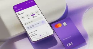 Mão com dinheiro e celular exibindo app Nubank