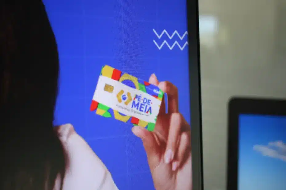 Estudantes consultam informações sobre o pagamento do programa Pé-de-Meia em um celular.