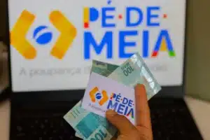 Estudantes do ensino médio recebem tablets em sala de aula, sorrindo.