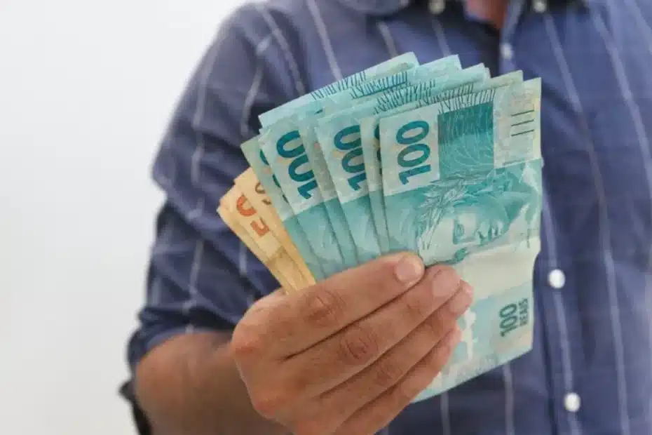 Trabalhador brasileiro com contracheque mostrando o novo salário mínimo de 2026.