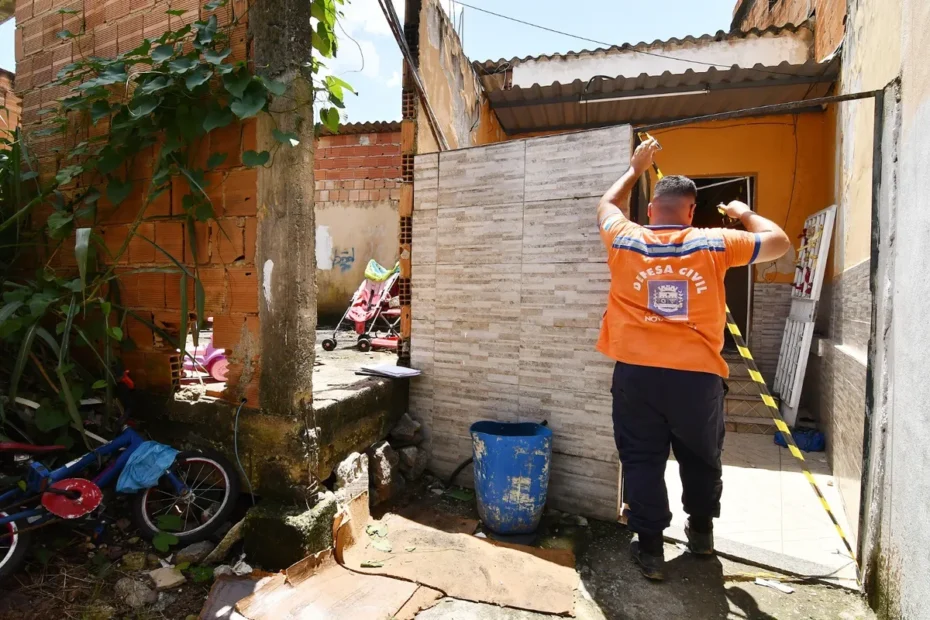 Moradores de Nova Iguaçu inspecionam sua casa danificada após enchentes e temporal de fevereiro