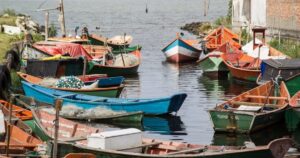 Pescadores artesanais reunidos em vila de pescadores ao amanhecer.