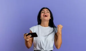 Mulher sorrindo com smartphone e cartão de crédito, simbolizando ganhos com cashback na Semana do Consumidor.