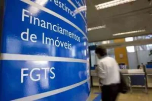 Mão de trabalhador segurando documento sobre mudanças na multa do FGTS, com fundo de parlamento borrado.