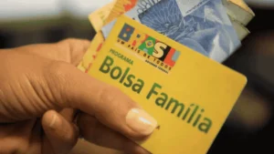 Mãe comemora recebimento do Bolsa Família visualizando saldo no celular.